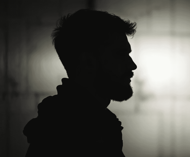 Silhouette of a man standing in front of a wall