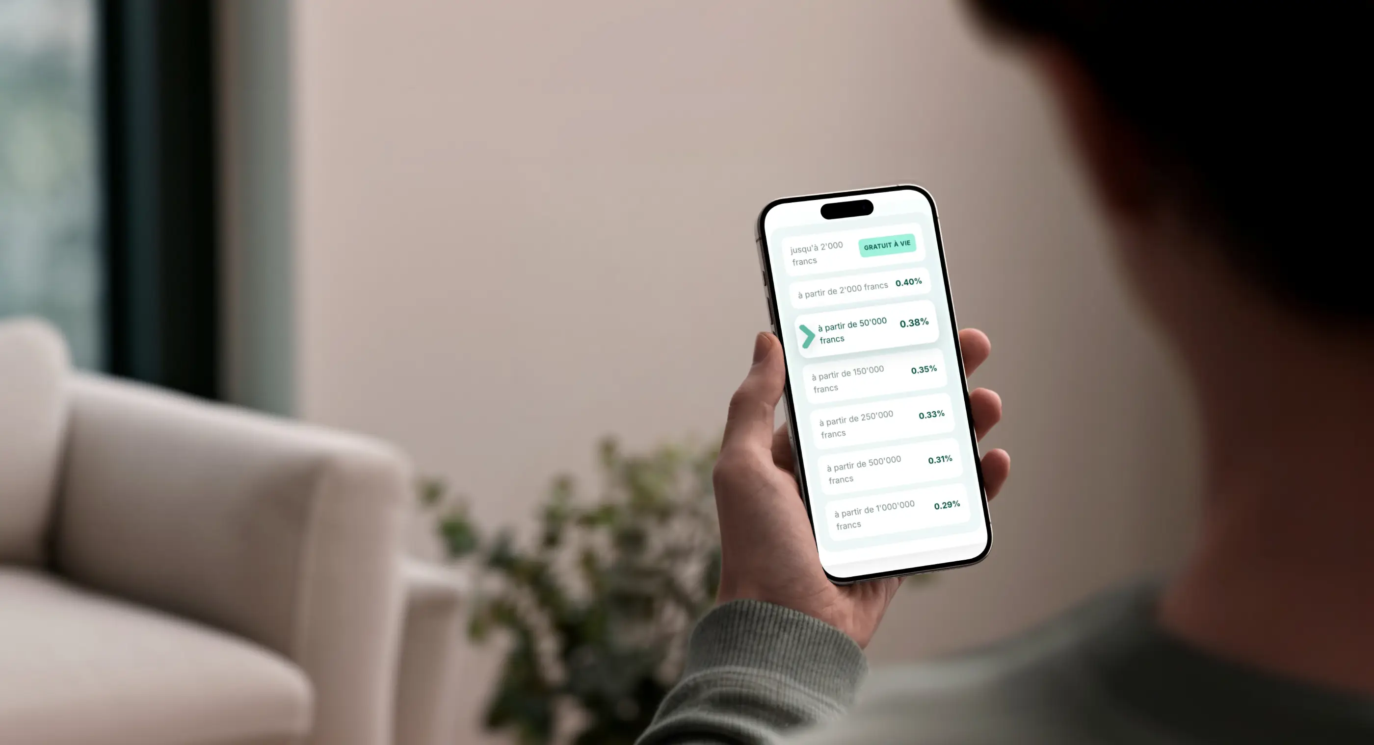 Un homme tient un smartphone affichant l’application d’investissement findependent.