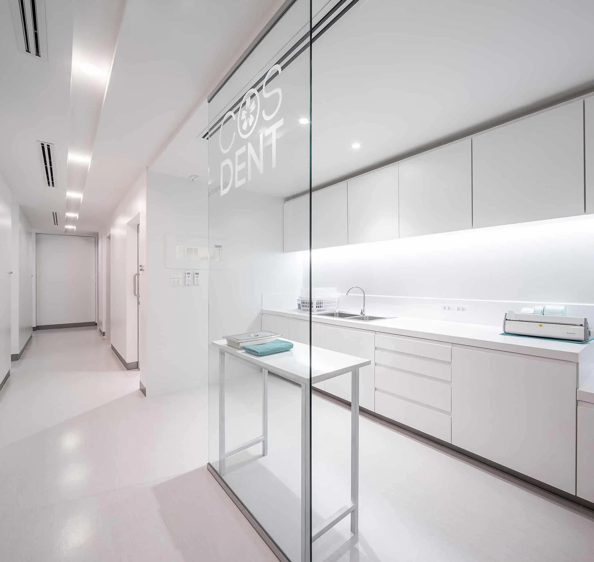 Sterilisation room behind glass with a long white worktop at COSDENT Rama 9
