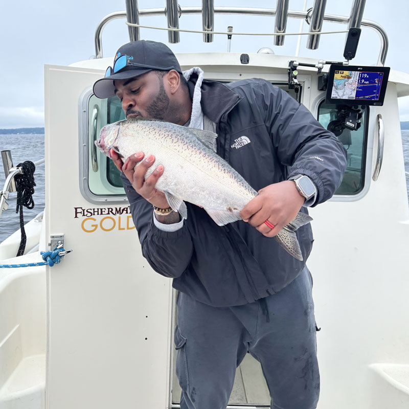 Guy on a boat holding a salmon