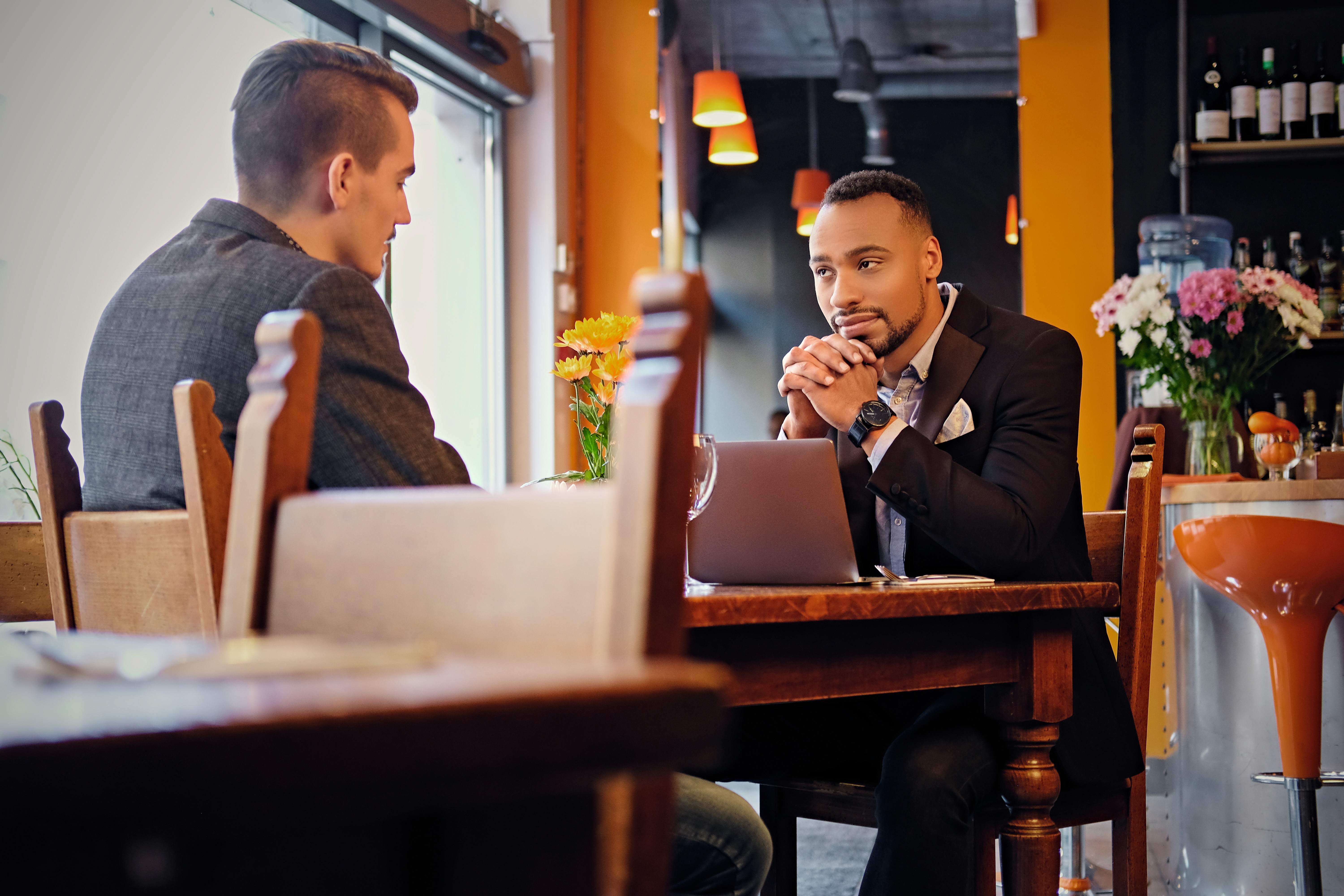 caucasian-black-american-men-having-business-meeting-restaurant