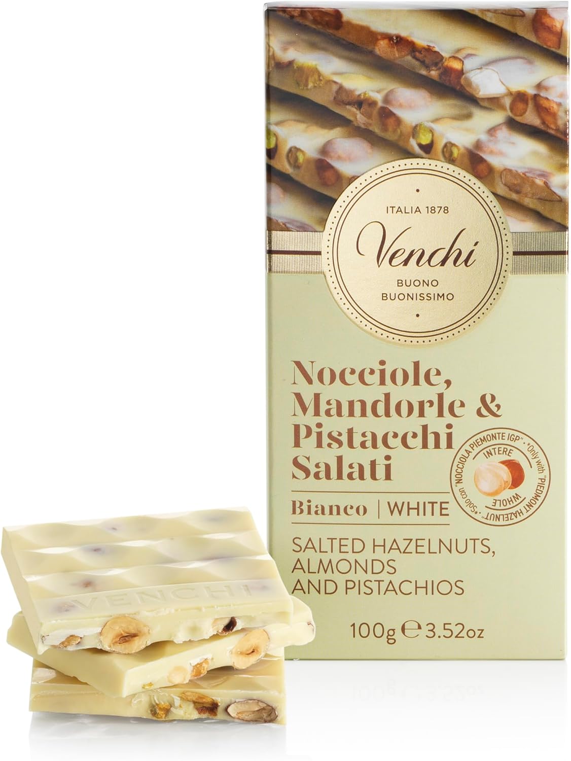 Smiling man in a grey blazer and graphic tee, lit by window shadows on a beige wall