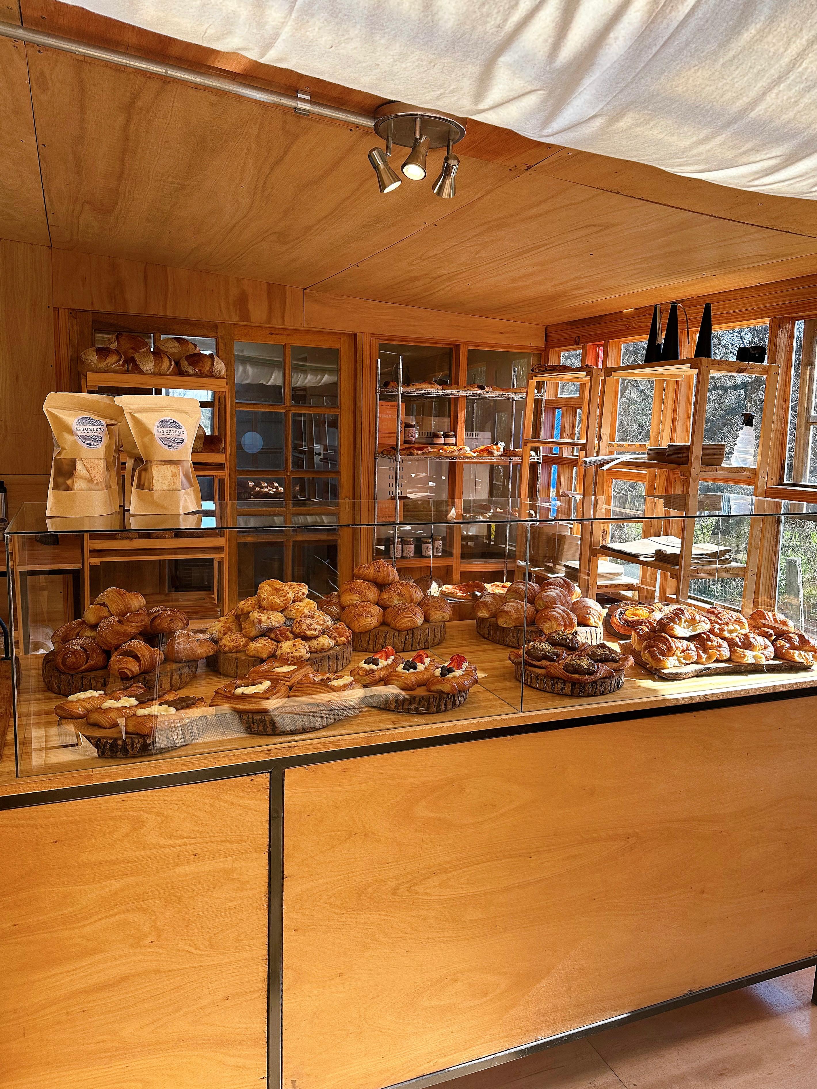 man in white dress shirt standing in front of brown wooden shelf
