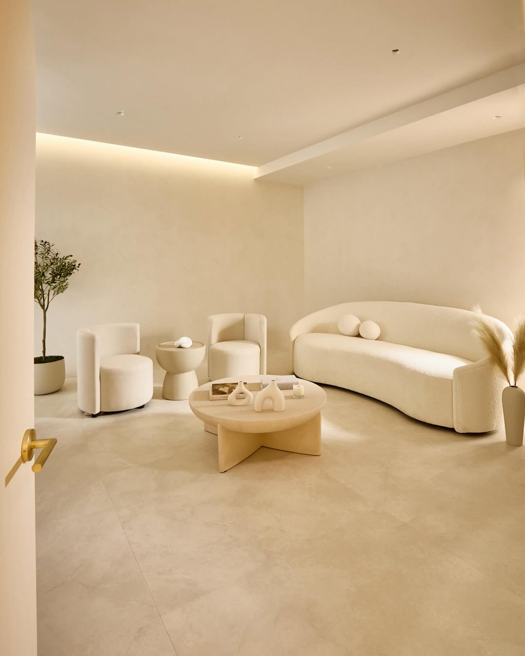 Minimalist dental clinic lounge with arched mirror, sculptural furniture, and soft neutral interior design at Terra Dental NYC.