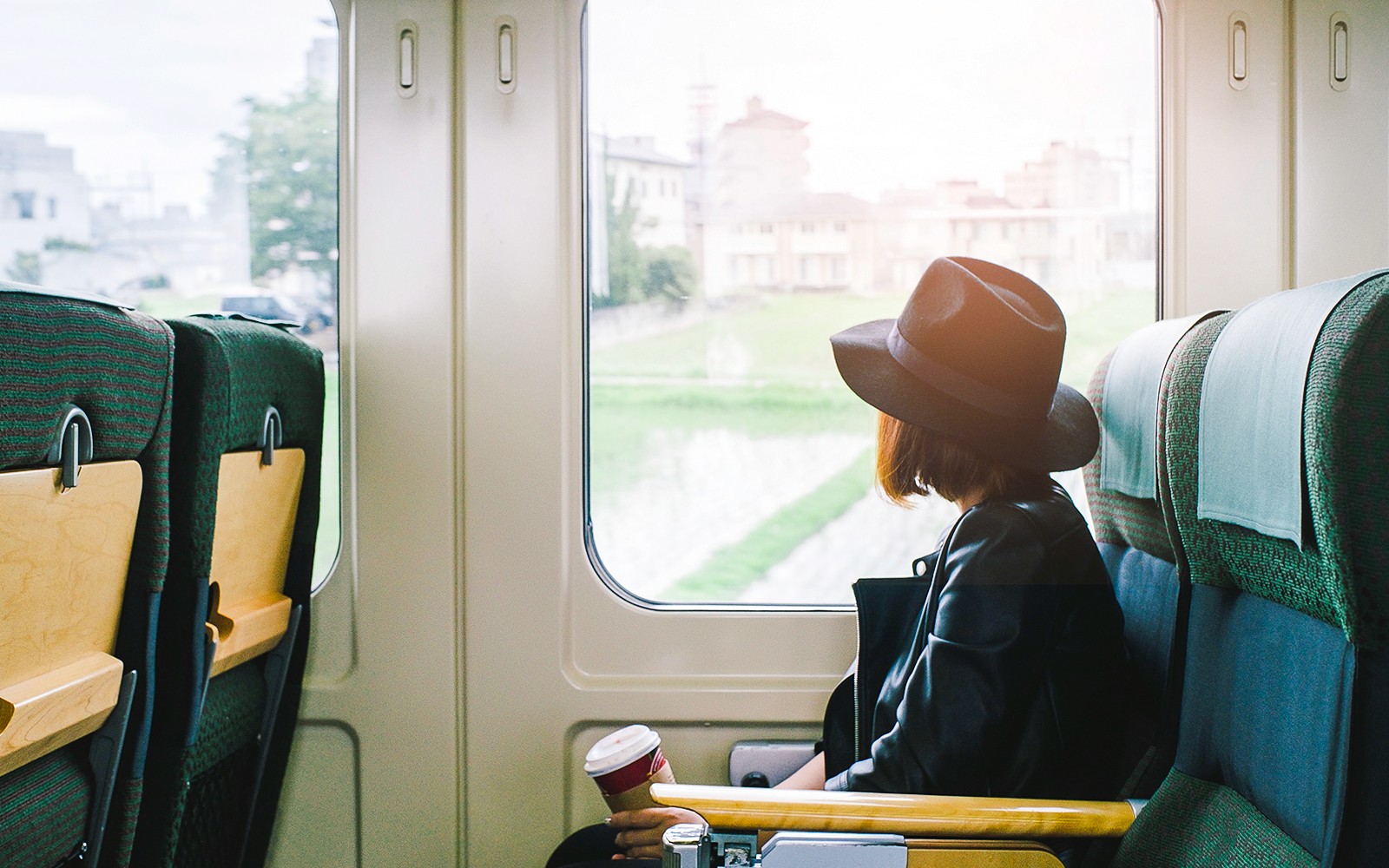 Mujer en tren en Japón mirando el pintoresco paisaje rural a través de la ventana.