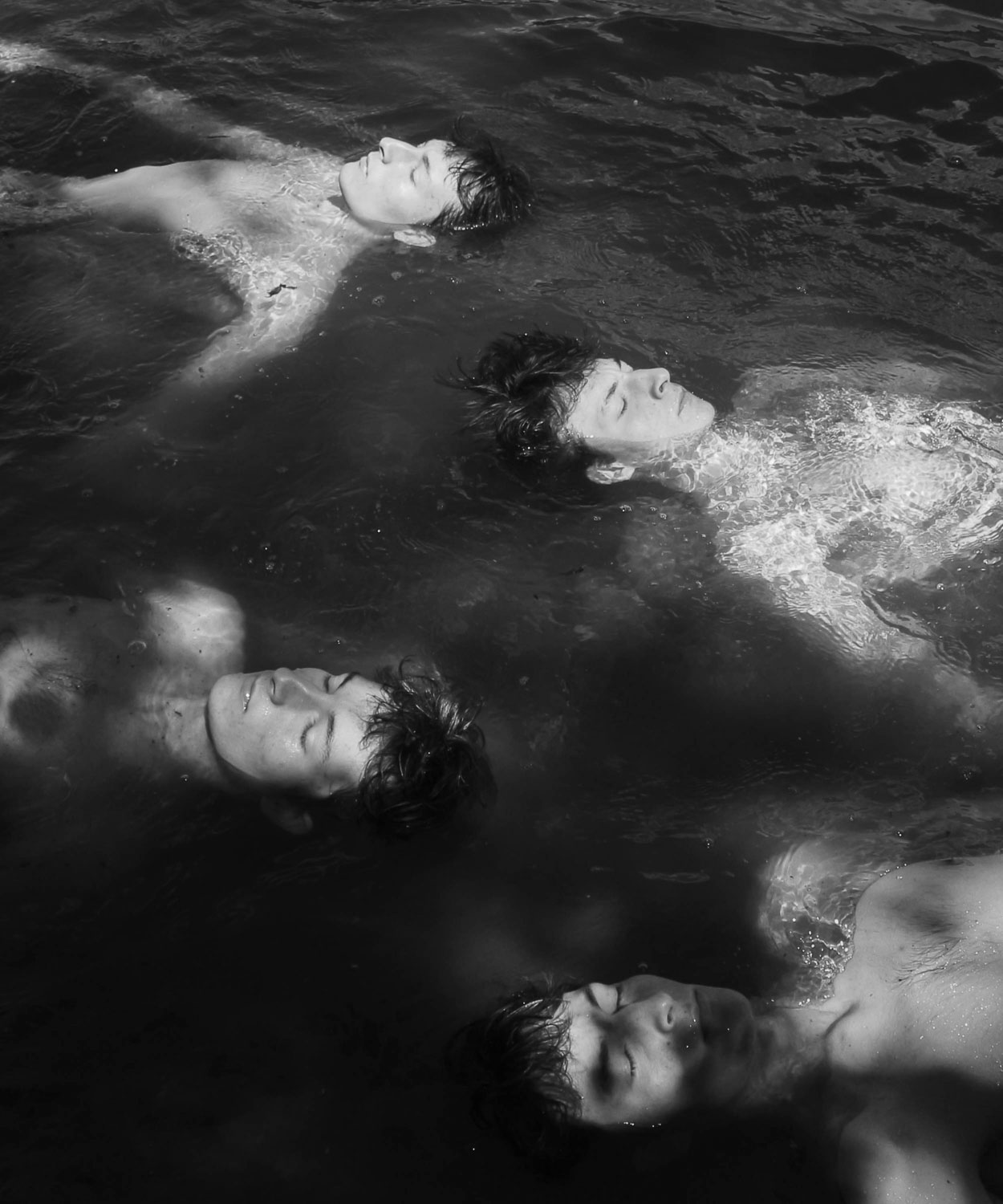 The same person in the water, four times, in black and white