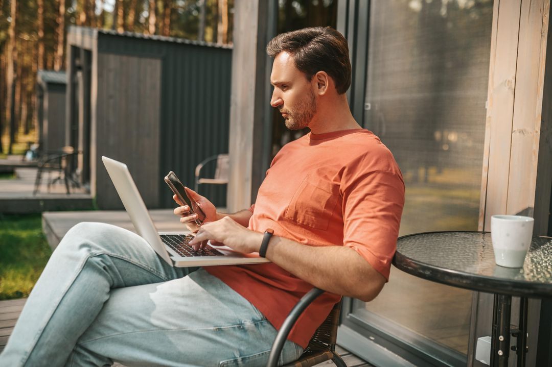 Person holding Laptop and Phone