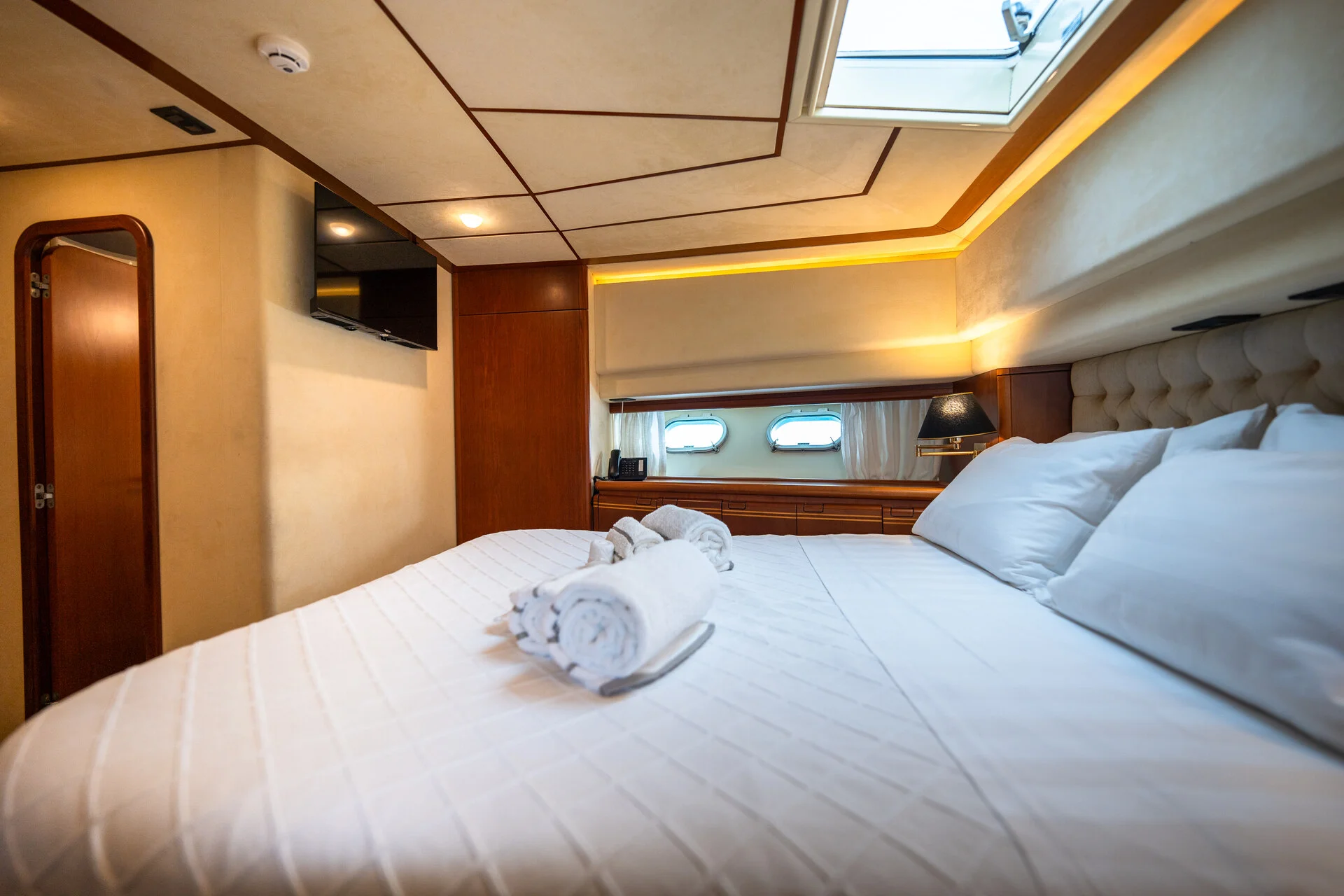 White Rock 36 speedboat with captain at helm cruising calm blue waters near Paros coastline with hills in background.