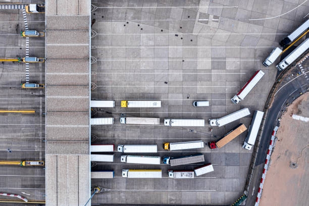 Image from a birds eye view of lorries in a line waiting to be loaded at a warehouse