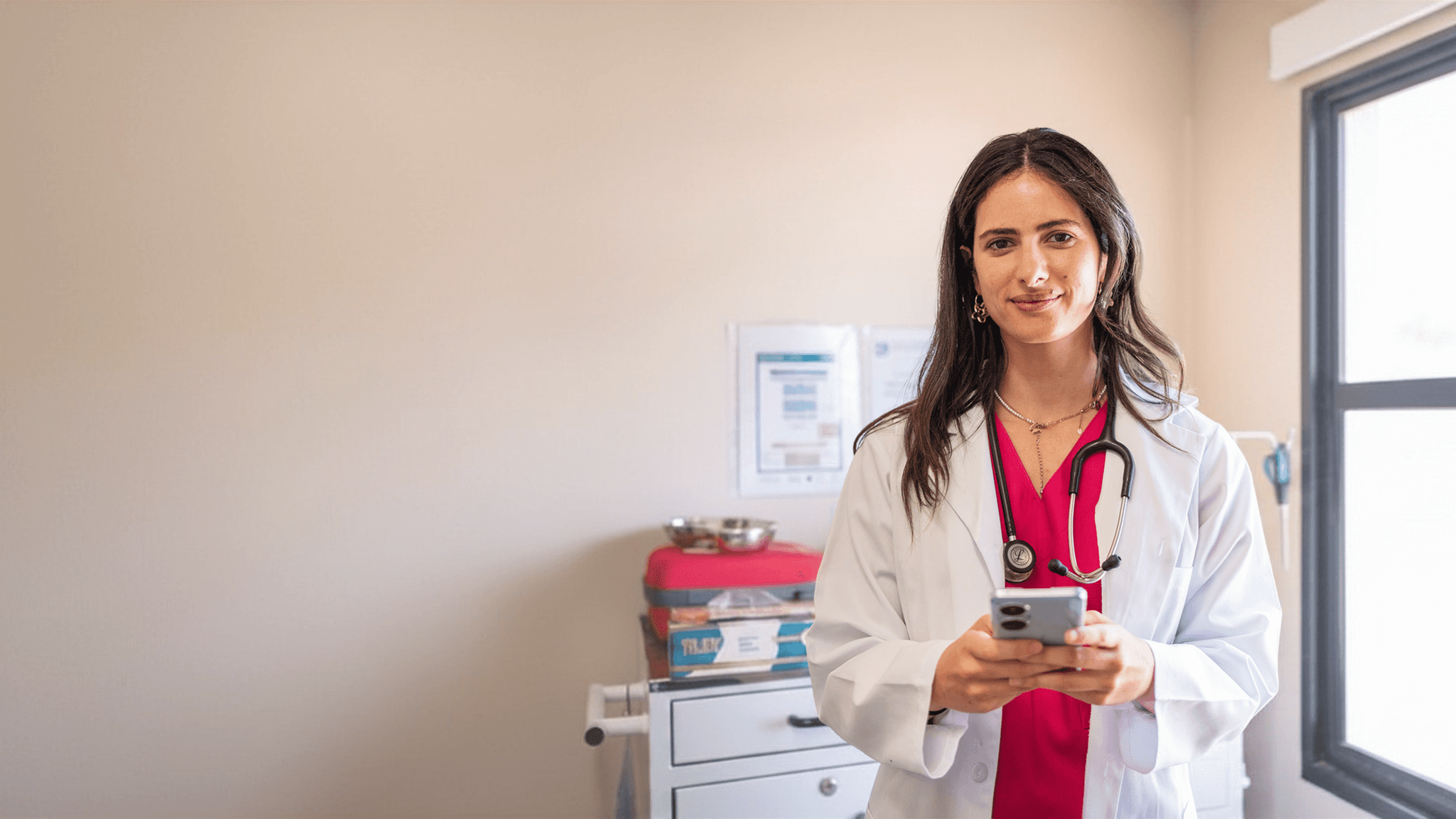 Photo of a female doctor looking at her phone. 