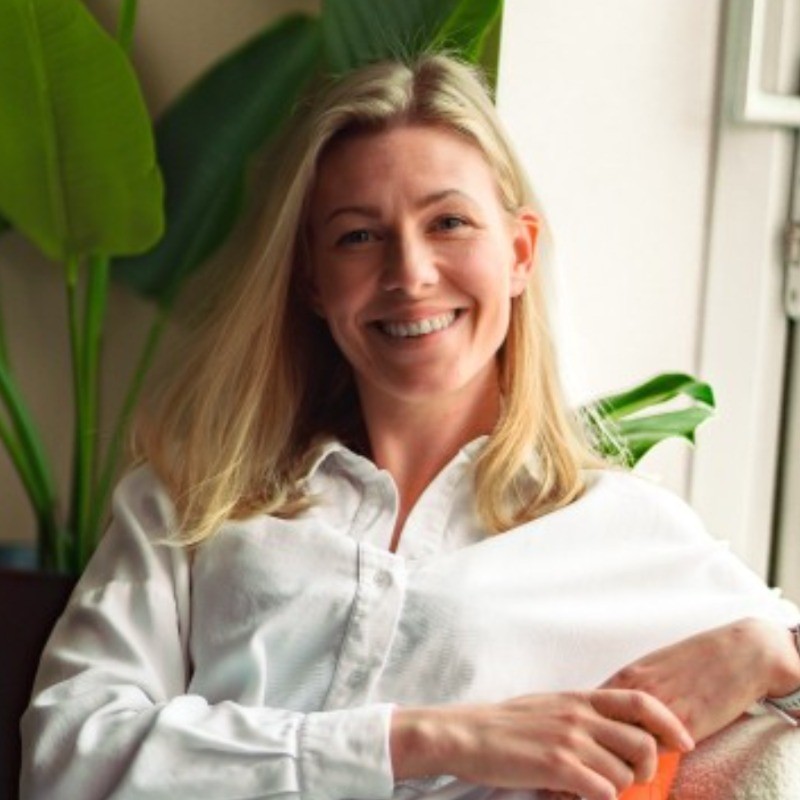 smiling woman wearing white and black pinstriped collared top