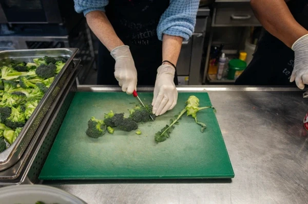 Volunteers preparing broccoli in the Compassion Soup Kitchen