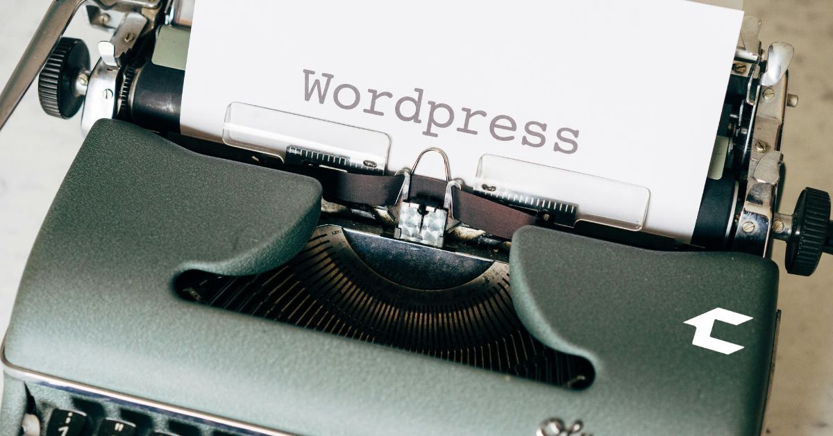 Máquina de escribir retro escribiendo la palabra WordPress, representando la creación de contenido en plataformas de diseño web tradicionales.