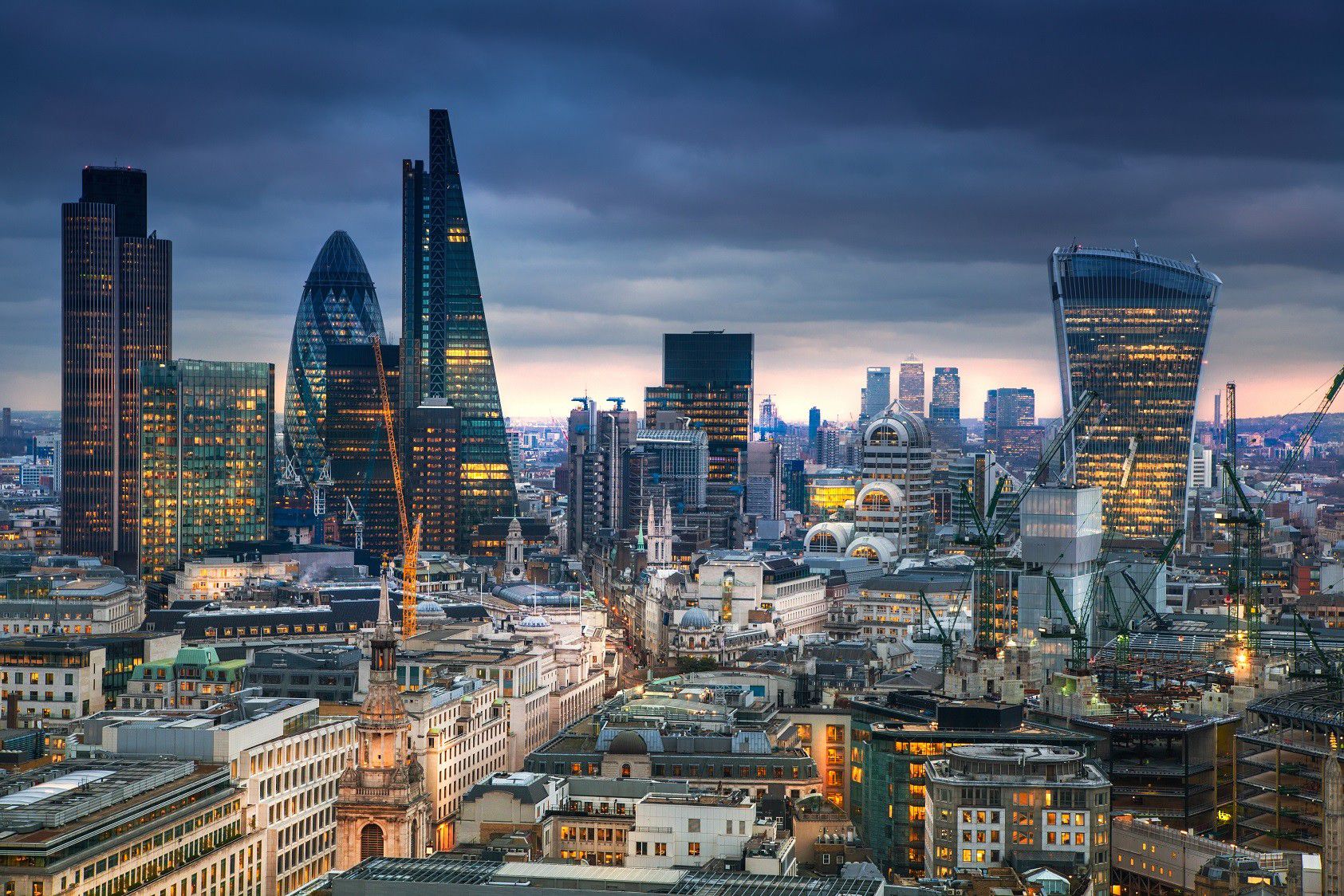 Panoramic view of the Houses of Parliament and Big Ben in London, captured during sunset with the River Thames and Westminster Bridge in the foreground, showcasing the iconic British architecture and city skyline.