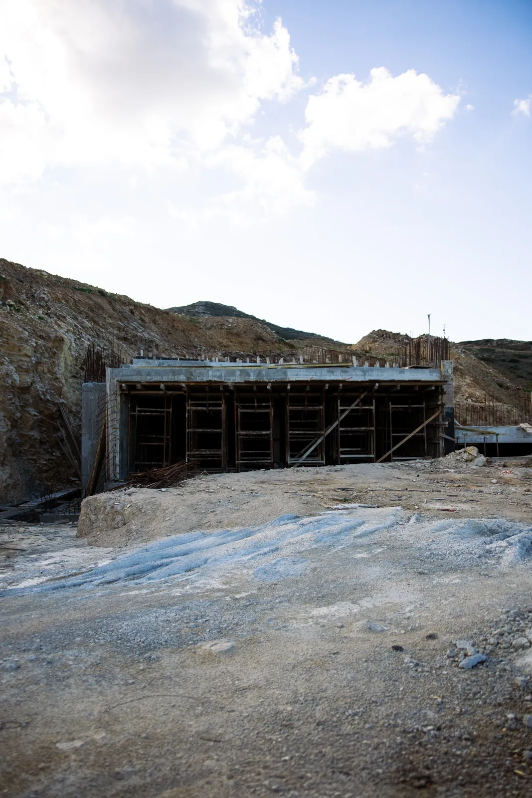 First walls rising from the hillside.