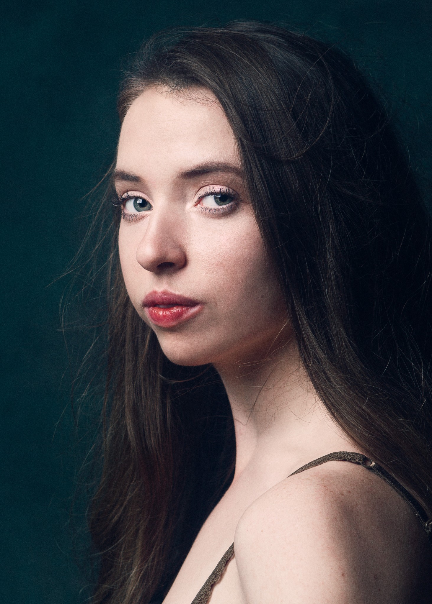 Editorial portrait of a ballet dancer with soft, cinematic lighting against a dark, textured backdrop.