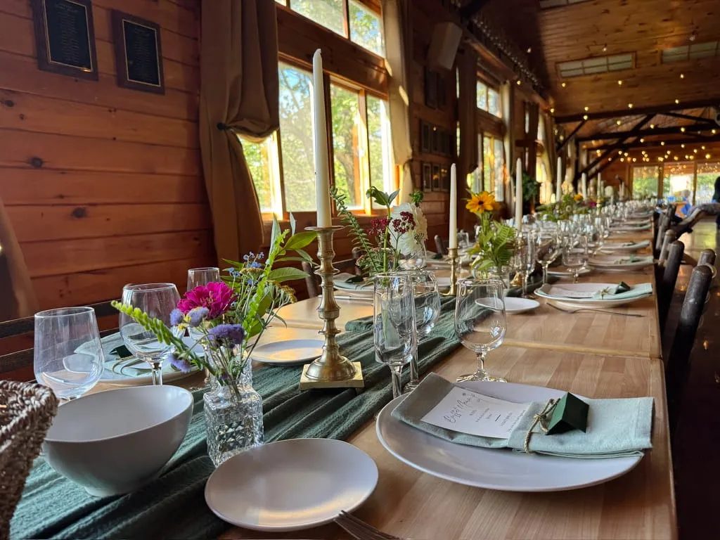 Long dining tables set for a retreat in the lodge at Camp Lenox