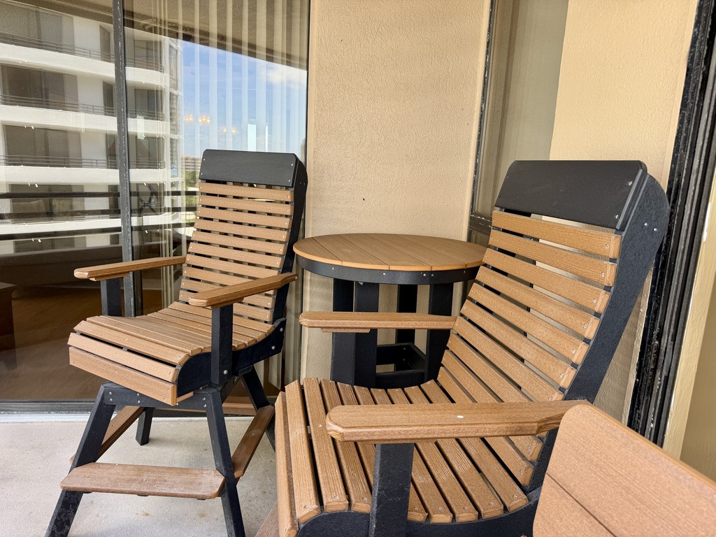 Balcony with two wood-slat chairs and a table, Unit 602 at Oceans Atrium, a vacation rental in Daytona Beach Shores