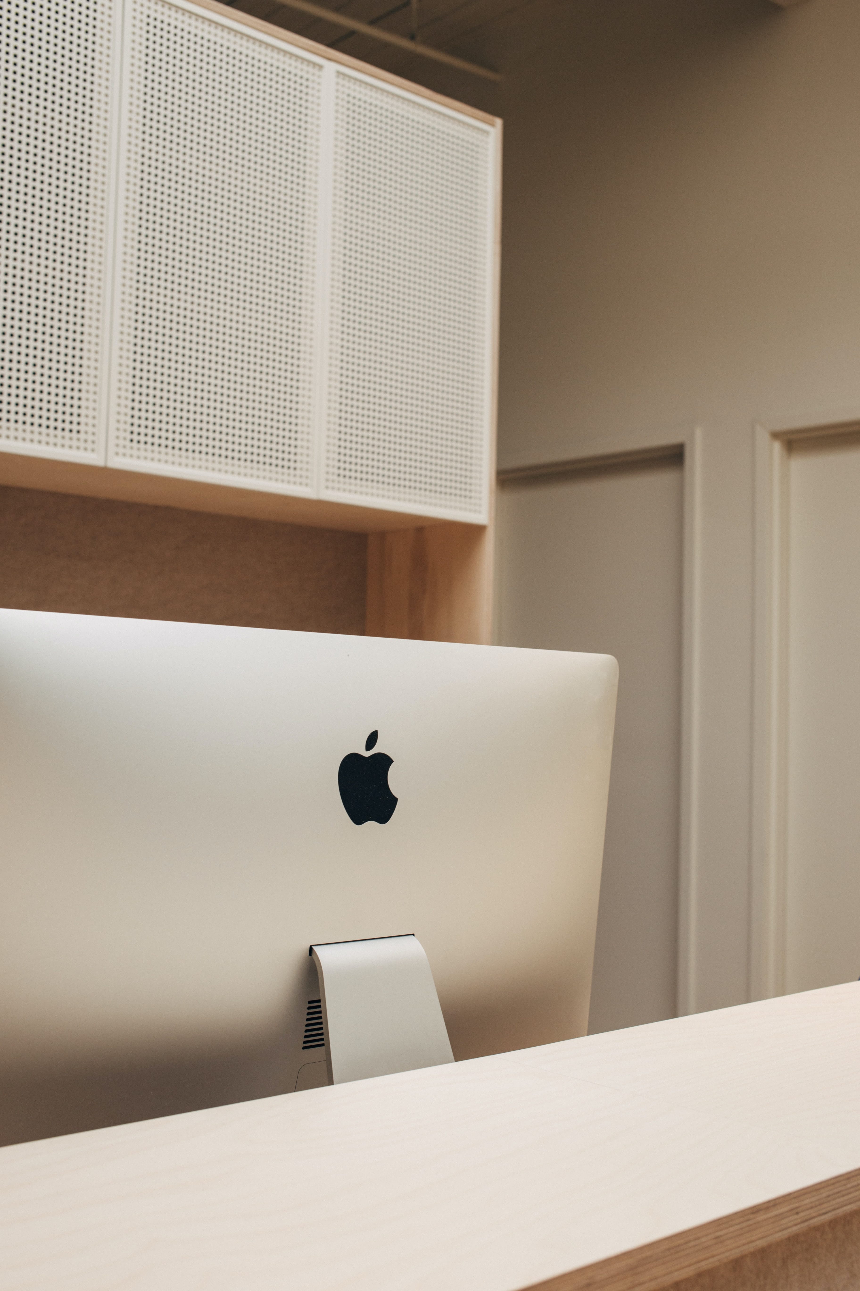 The back of an imac on a wooden desk