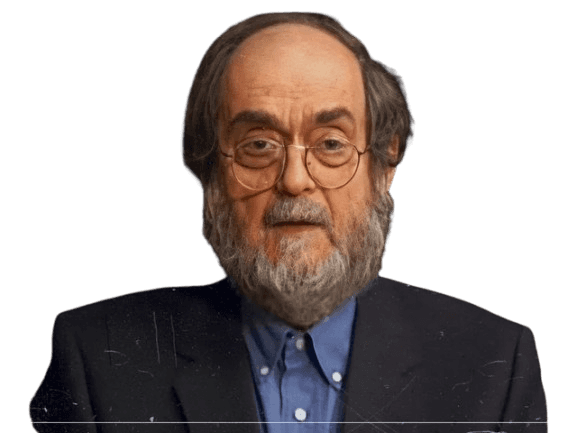 A portrait of an older man with a full beard, glasses, and thinning hair. He is dressed in a dark suit jacket over a blue collared shirt, giving him a thoughtful and intellectual appearance. The image has a slightly grainy, vintage texture, which adds a classic and artistic feel to the photograph. The dark background enhances the focus on his serious expression and formal attire.