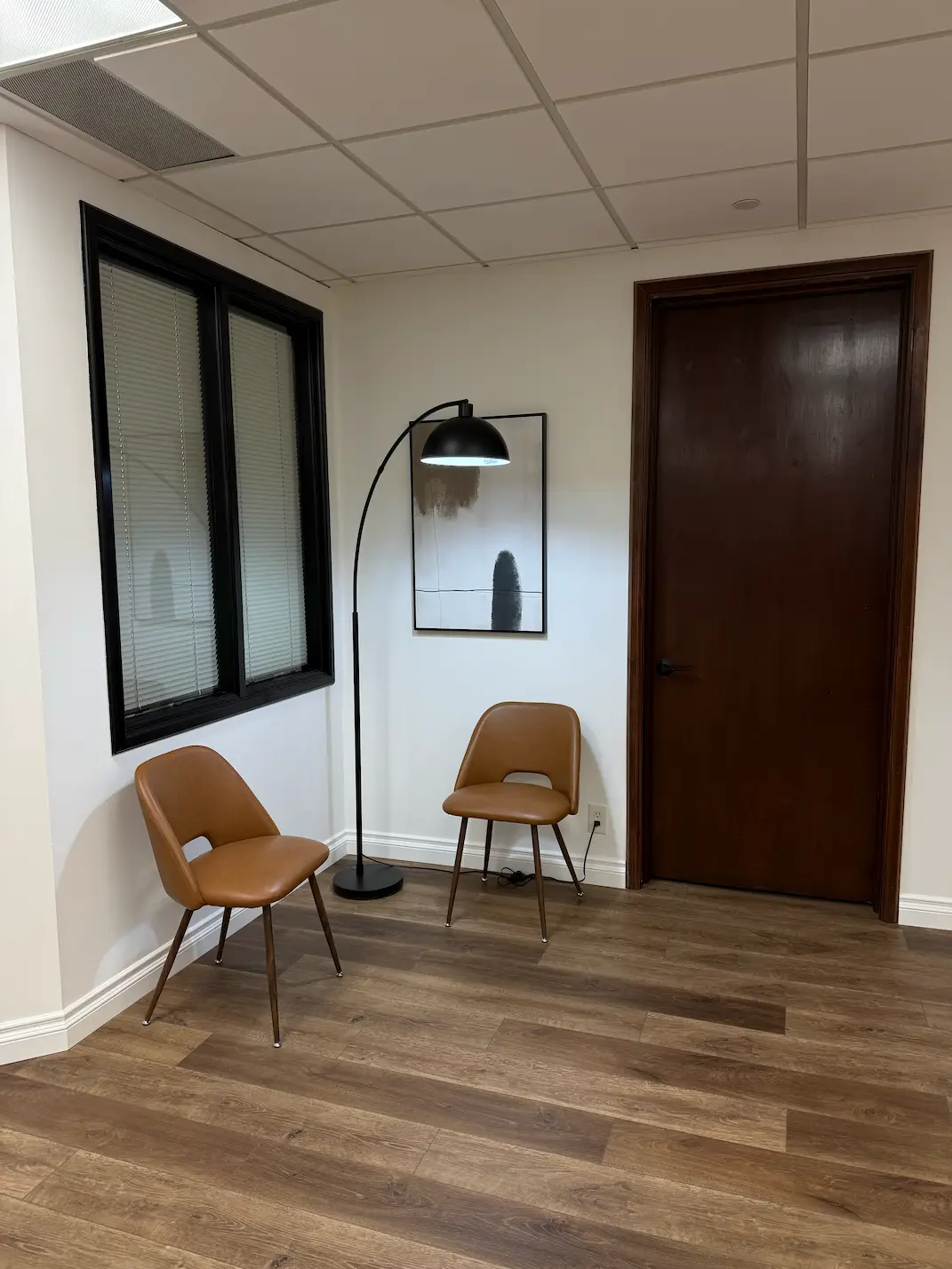 Shared vanity area with multiple illuminated mirrors and pink chairs