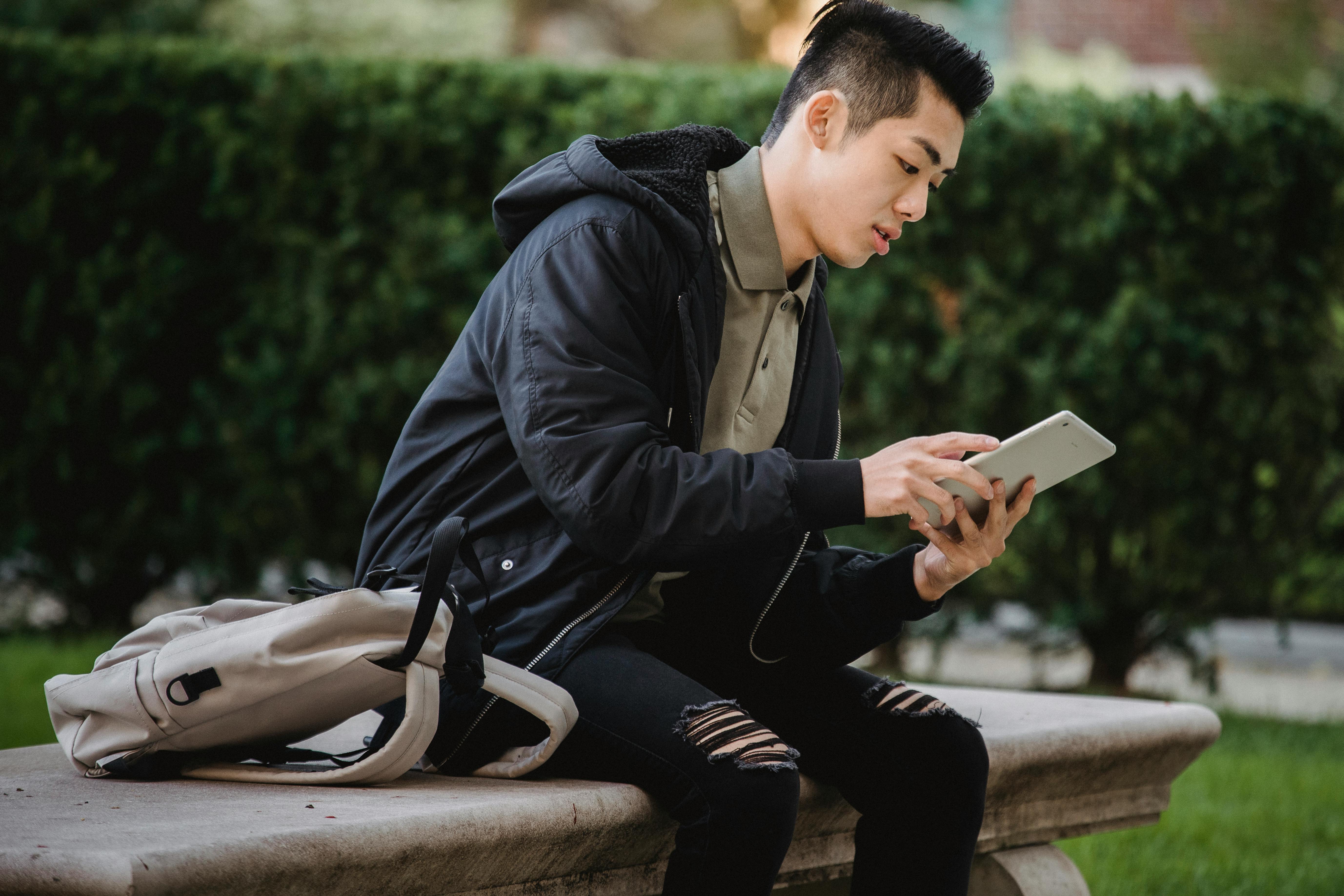 Man reading his tablet outside