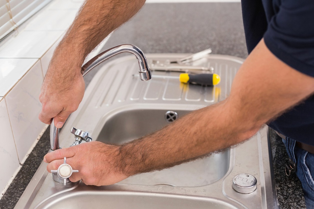 Plumber fixing a tap