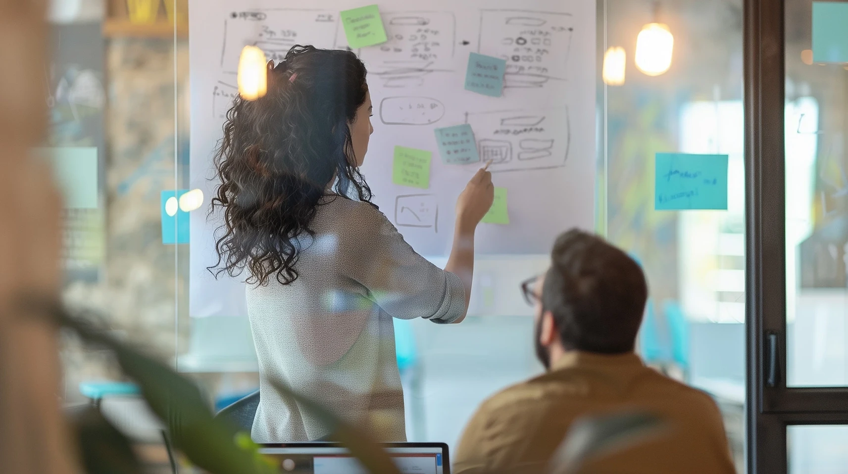Product designer mapping out user flows and wireframes on a whiteboard during a strategic MVP workshop. The session focuses on transforming complex startup technology into a clear, investable asset to prepare for pre-seed fundraising