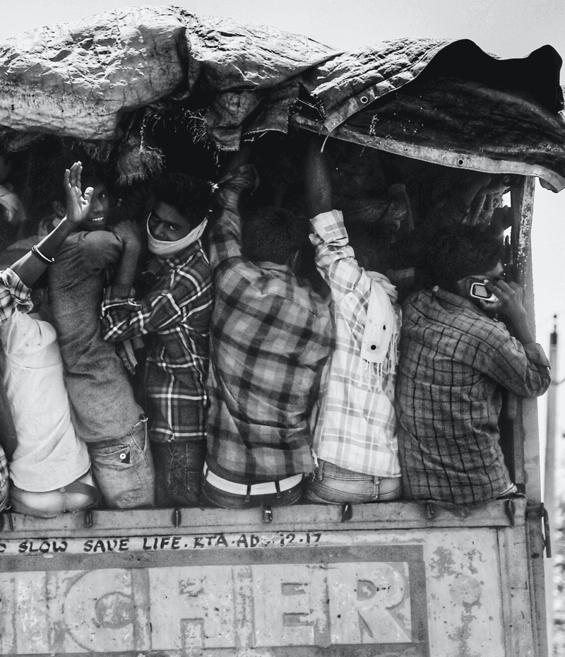 A group of people gathered under a makeshift canopy, engaged in conversation and activity.