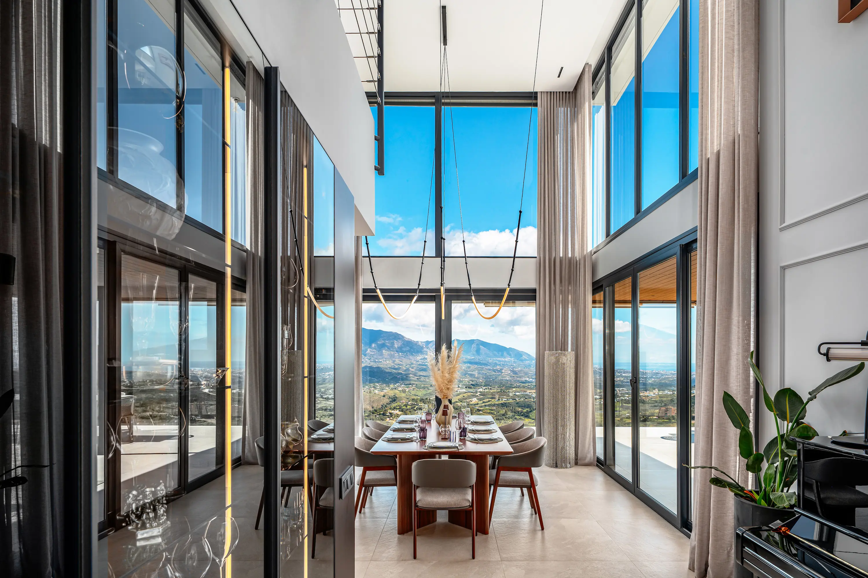 Villa Vista Marbella double-height dining area with panoramic glazing and mountain views