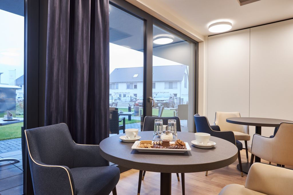 Modern interior room with panoramic windows, dining table, comfortable seating, natural lighting, and outdoor views