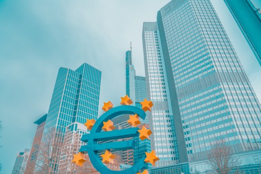A blue sky with modern skyscrapers and a large euro symbol in the foreground.