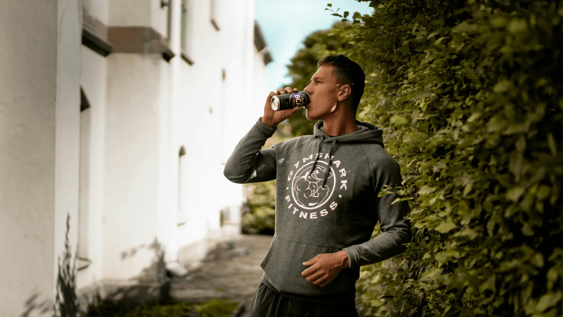 A person, sporting merch, drinks for a bottle