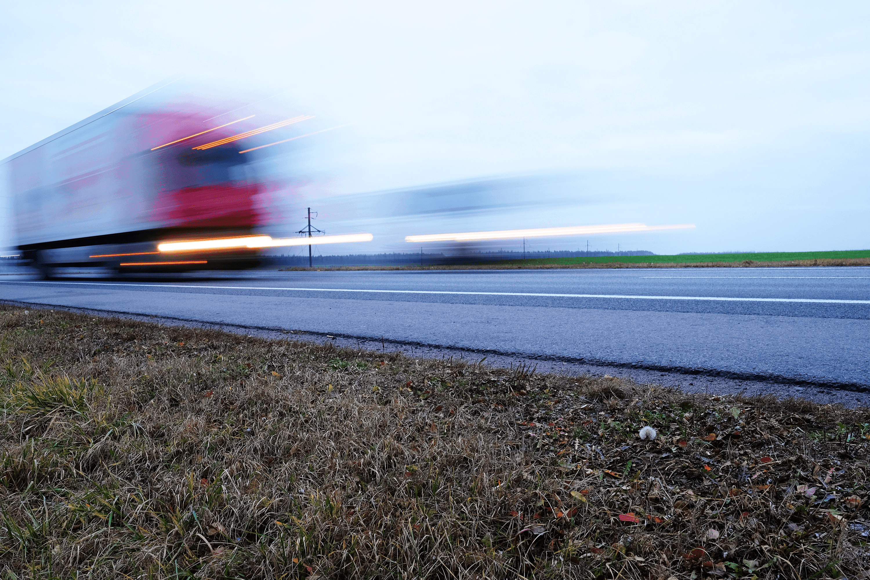 image photographed with a long exposure aperture to record the passage of a red truck on a highway, thus obtaining a high-speed effect