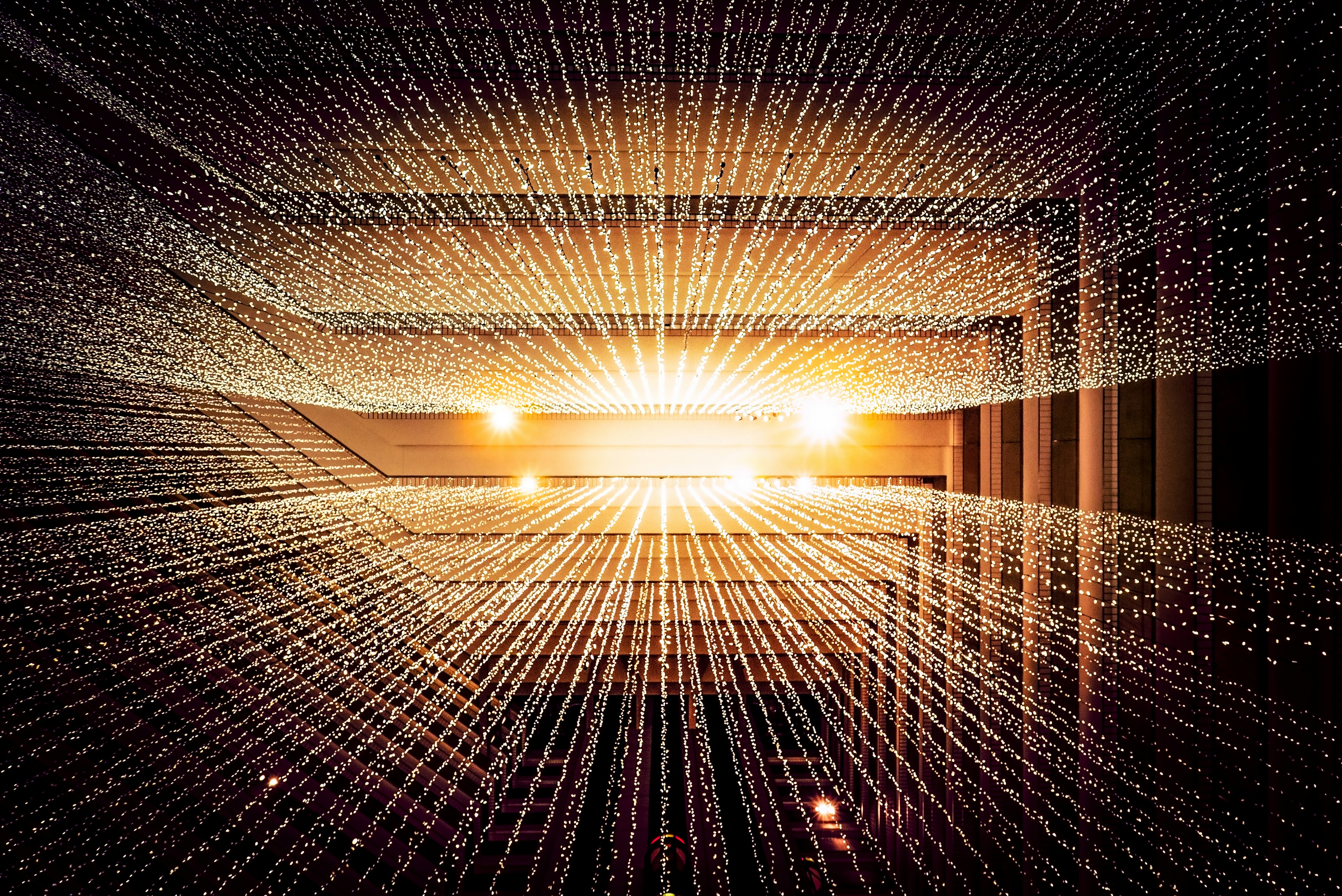 Abstract visualization of light beams and digital particles emanating from a central point, symbolizing data flow and technology.