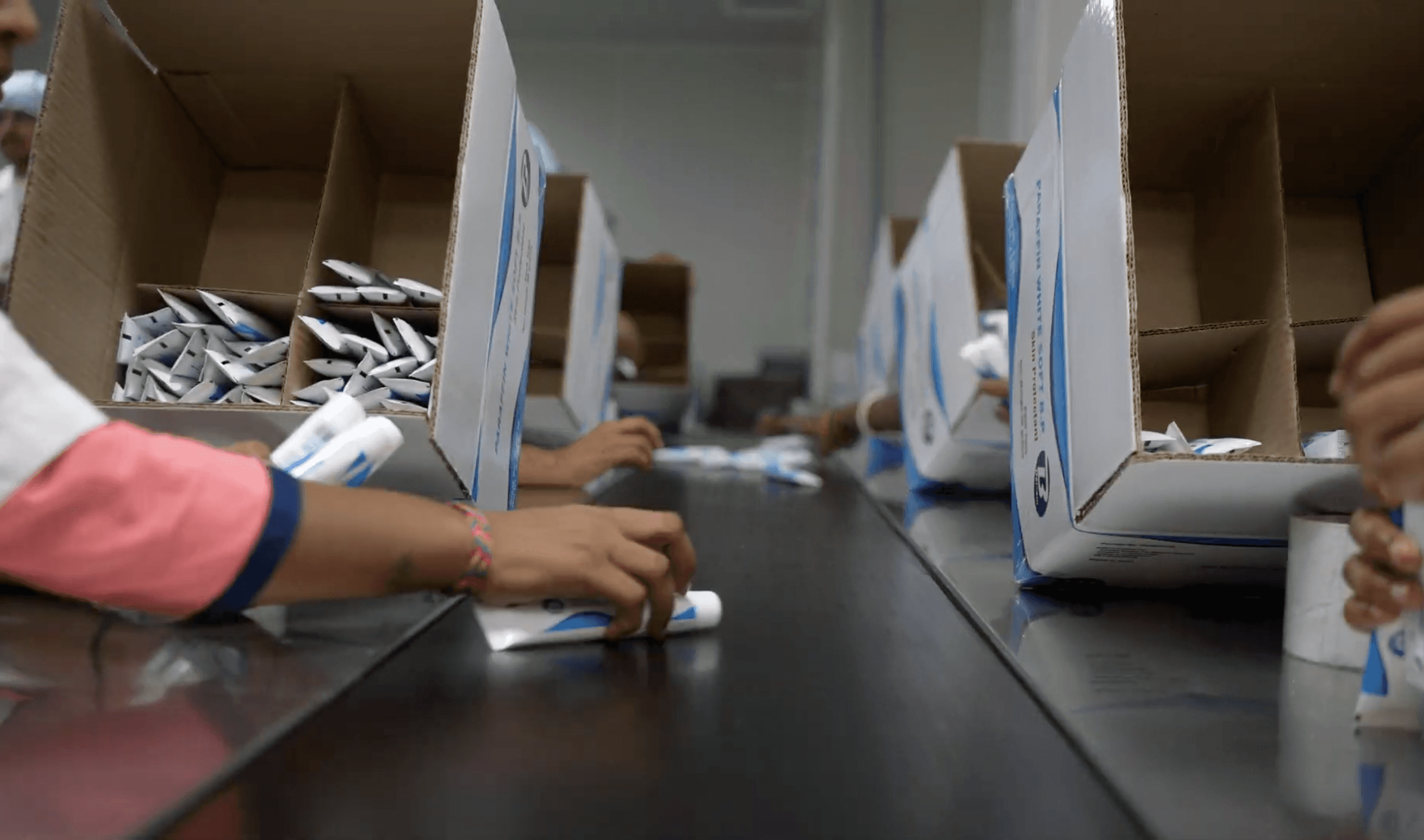 A woman in a straw hat stands in the grass