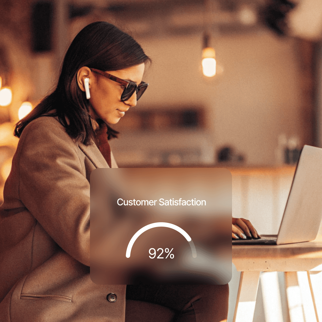 Woman in sunglasses working on laptop with customer satisfaction gauge at 92% in a cafe setting.