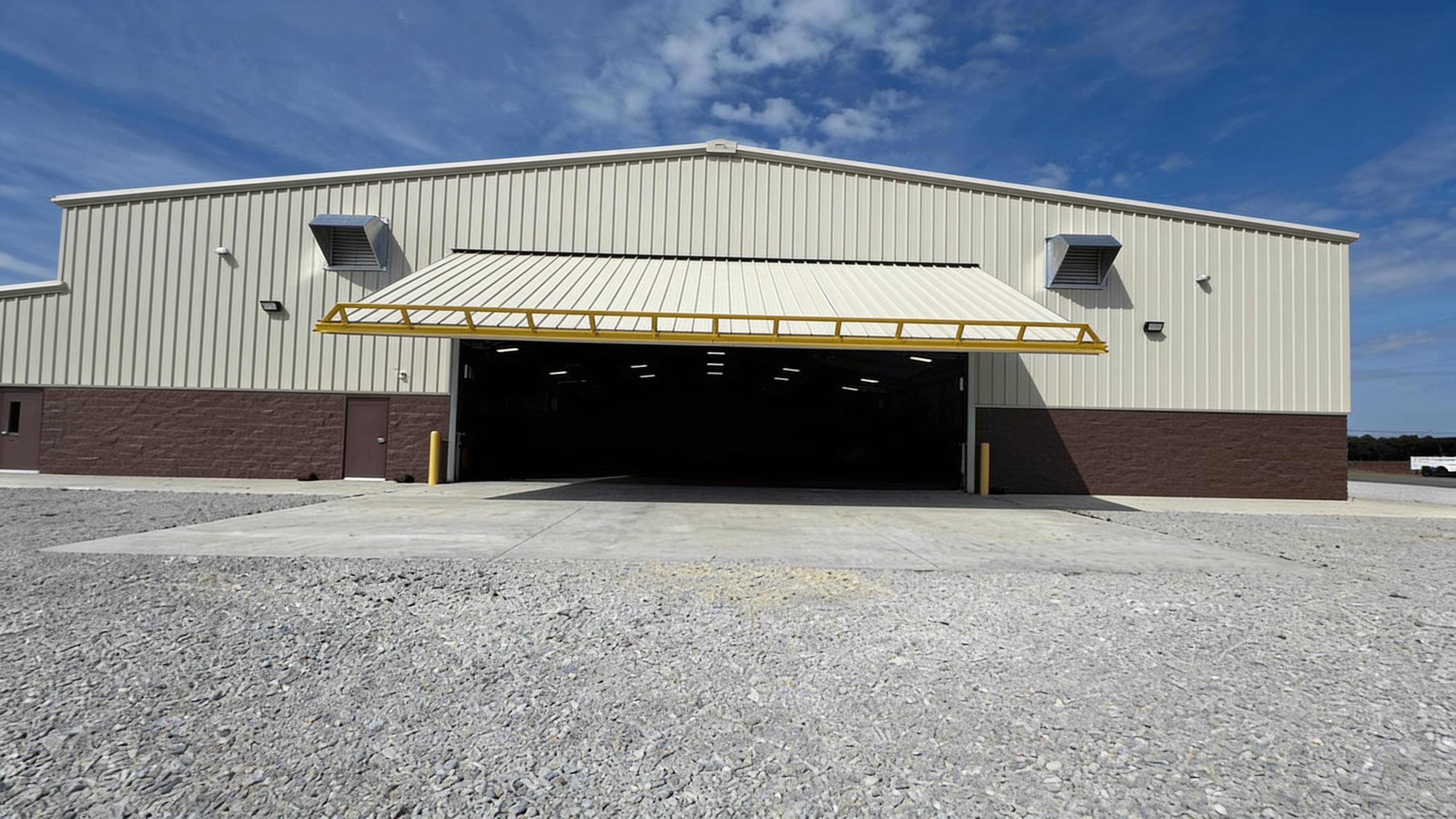Metal shop facility with an open hydraulic door and semi truck