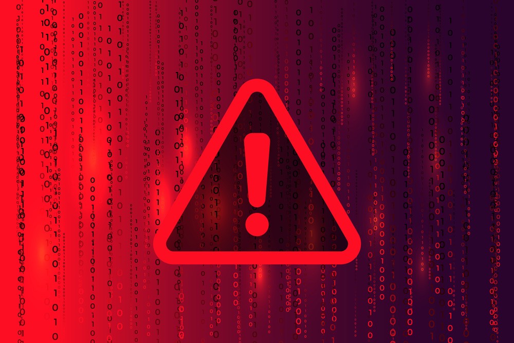 Red digital warning symbol glowing on a circuit board interface, representing active ransomware exploitation of the VMware ESXi CVE 2025 22225 vulnerability and hypervisor compromise.