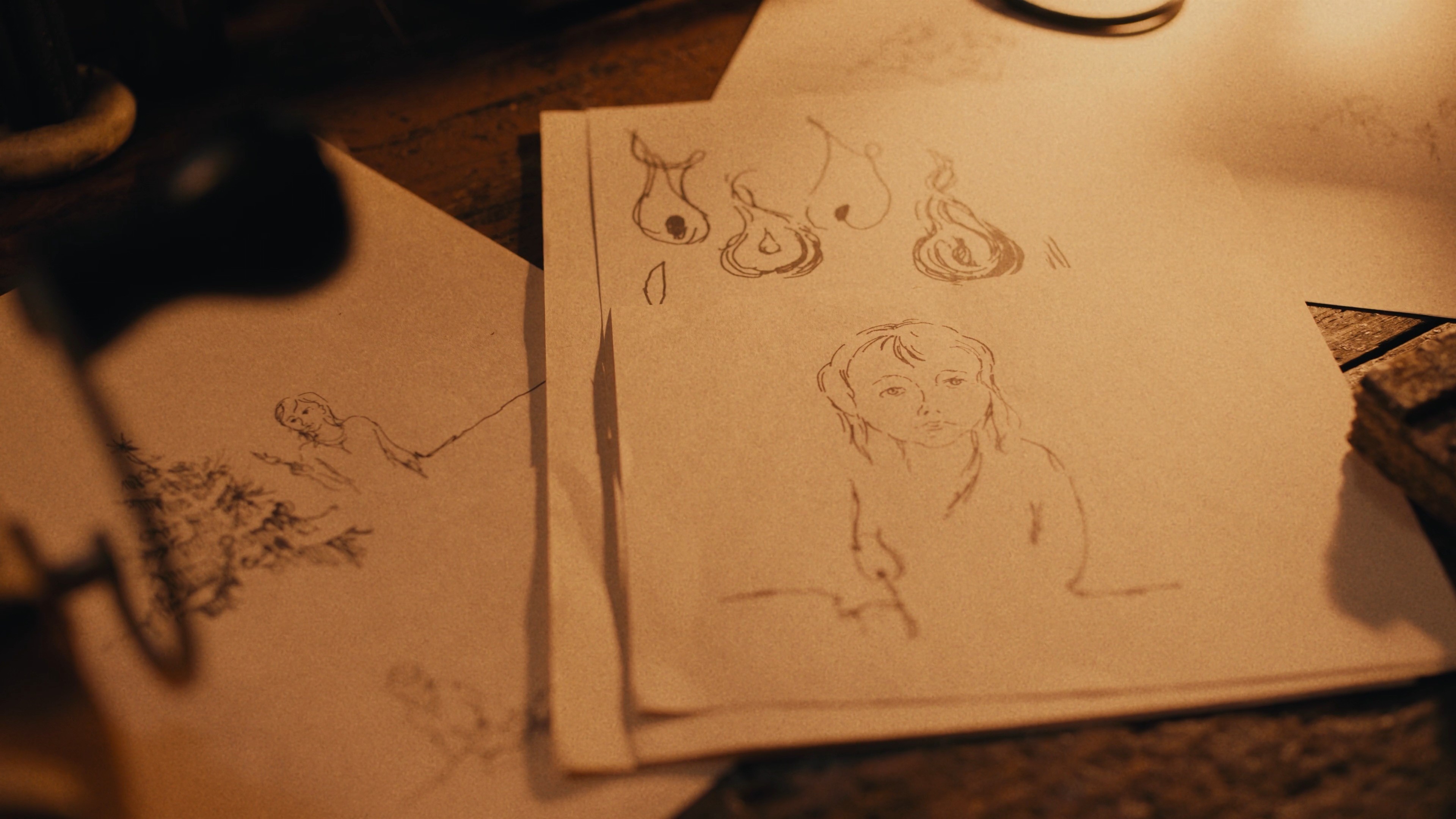 Close-up detail of hand-drawn sketches on a wooden desk, warm color grading.