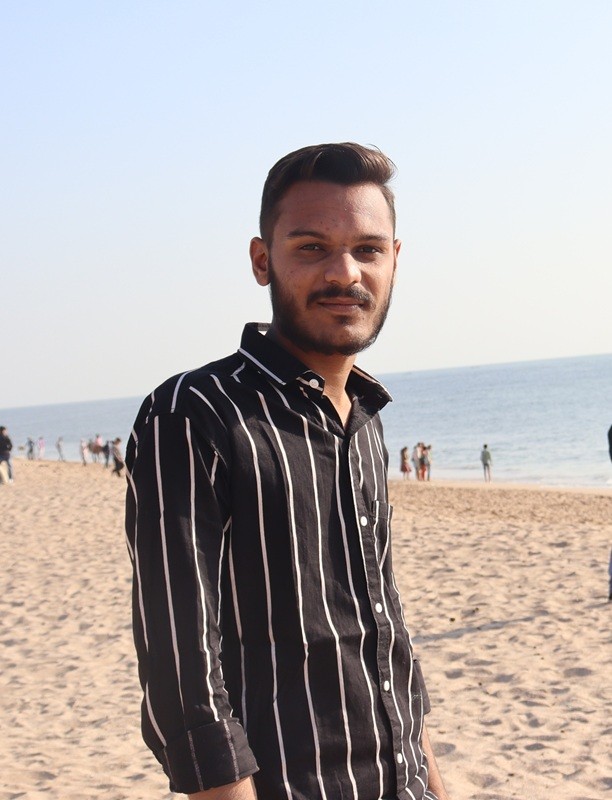 Black and white photo of two people looking at a computer screen with papers on wall
