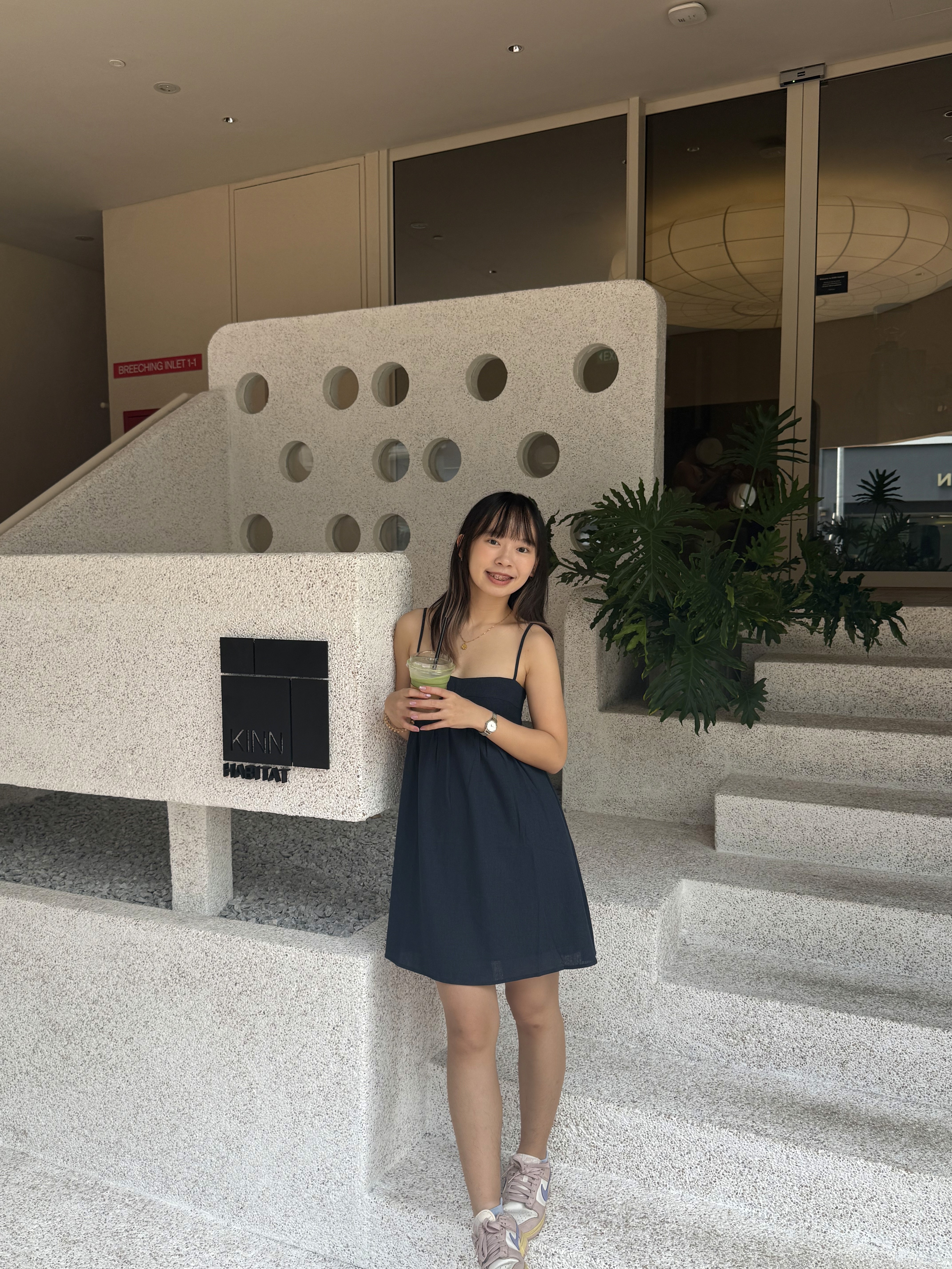 A thoughtful young person with dark hair gazes to the side, captured in soft black and white lighting.