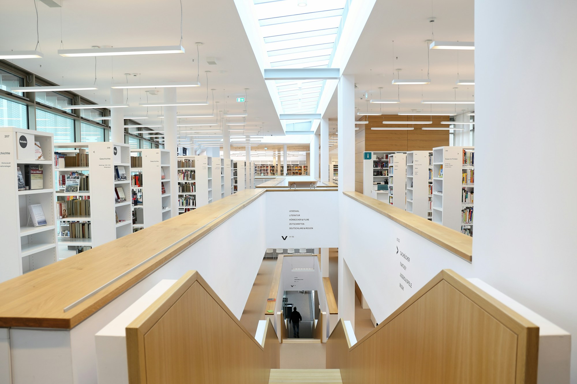 Bright library with white shelving over two levels