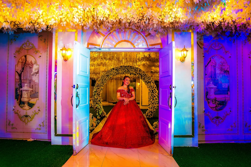 Debutante in a crimson ballgown at the doors of Celestia Hall, Stalla Suites QC
