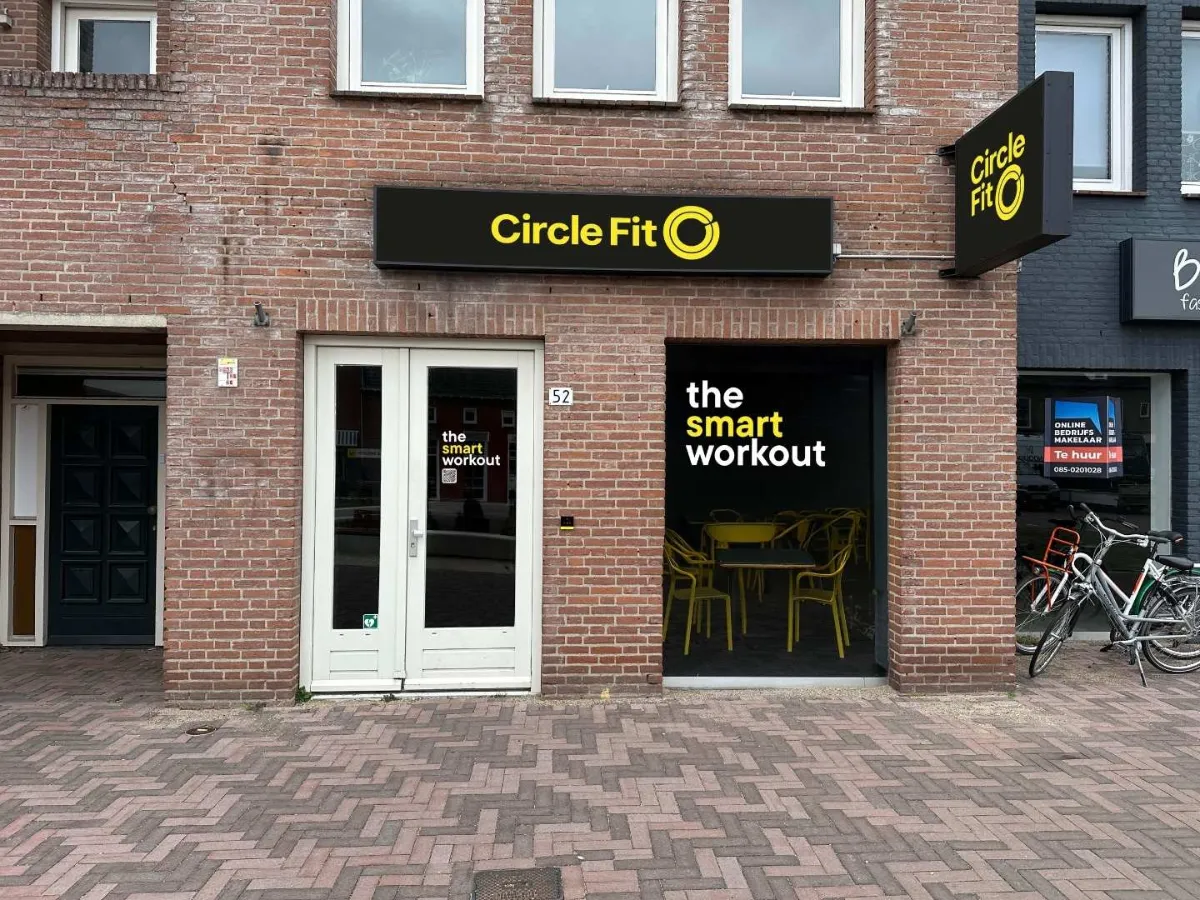 Exterior of a Circle Fit hub with a sign reading "GET IN THE CIRCLE" and double doors in front.