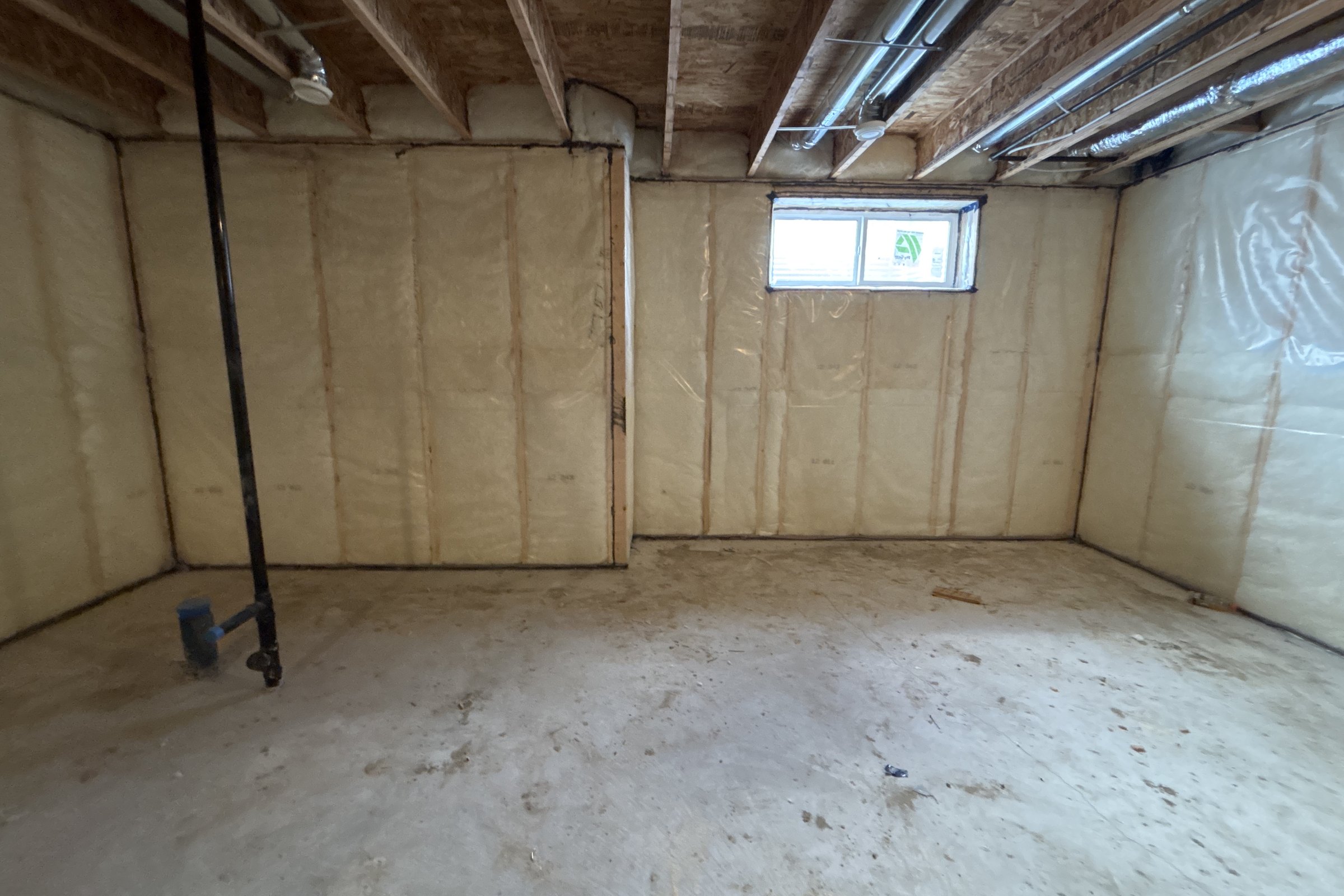 Unfinished basement before: insulated walls and a small window
