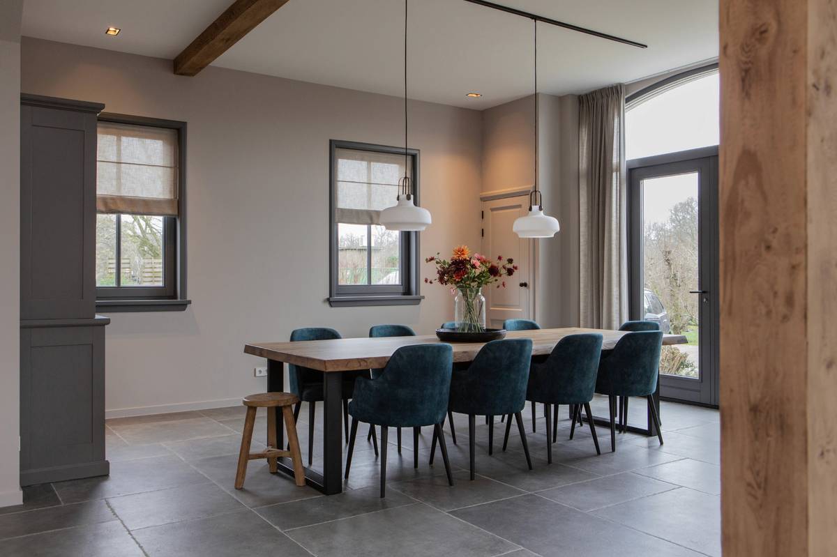 boomstamtafel met blauwe stoelen in velours in schuurwoning