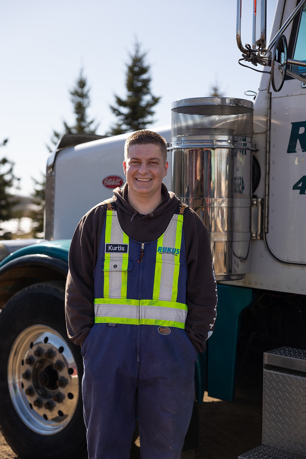 Rukus Liquid Waste Removal owner Kurtis Lozinski standing in front of a company vacuum truck in Calahoo, Alberta, serving Edmonton and surrounding areas with septic and liquid waste services.