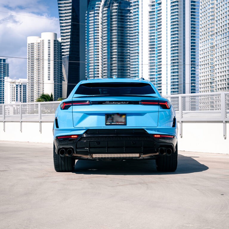 Rear view of blue Lamborghini Urus S, black wheels, exotic SUV rental.