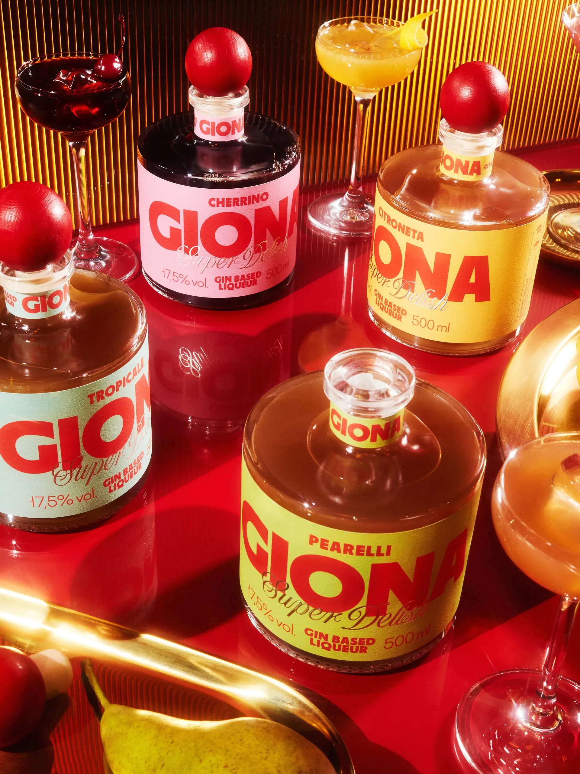 Four Giona liqueur flavours arranged on a red table with cocktails and a pear, gin-based liqueur packaging system